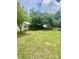 The home's expansive backyard boasts mature trees, a screened porch, and a wooden fence at 4639 Cabbage Palm Dr, Valrico, FL 33596