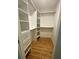 Walk-in closet with custom shelves, drawers, and wood flooring at 4639 Cabbage Palm Dr, Valrico, FL 33596