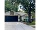 Charming single-story home featuring a dark garage door, beige stucco, and mature shade tree at 4639 Cabbage Palm Dr, Valrico, FL 33596