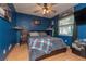 A blue bedroom with dark wood floors, a fan, and a window letting in natural light at 516 7Th Se St, Largo, FL 33771