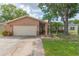 Charming single-story home with a beige exterior, a two-car garage, and beautiful landscaping at 516 7Th Se St, Largo, FL 33771