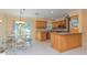 Bright kitchen with wood cabinets, granite countertops, stainless steel appliances, and adjacent dining area at 516 7Th Se St, Largo, FL 33771