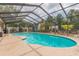Large in-ground pool with screened enclosure and a gazebo in the background at 516 7Th Se St, Largo, FL 33771