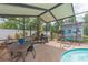 Enclosed pool area featuring an outdoor dining area with a barbecue grill at 516 7Th Se St, Largo, FL 33771