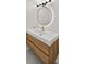 Bathroom featuring a light wood vanity, backlit mirror, and modern fixtures at 5430 Eagles Point Cir # 202, Sarasota, FL 34231