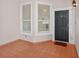 Cozy entrance to unit 202 with tile flooring, windows and a dark-colored front door at 5430 Eagles Point Cir # 202, Sarasota, FL 34231