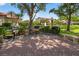 Outdoor grill area with multiple barbecue stations and serene view of a pond at 5430 Eagles Point Cir # 202, Sarasota, FL 34231