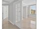 Hallway with glass paneled doors, white trim and neutral tile flooring at 5430 Eagles Point Cir # 202, Sarasota, FL 34231