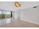 Spacious living room with neutral walls, tile flooring, balcony access, and a modern light fixture at 5430 Eagles Point Cir # 202, Sarasota, FL 34231
