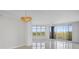 Bright living room with white walls, tile floors, modern light fixture, and balcony access with a view at 5430 Eagles Point Cir # 202, Sarasota, FL 34231