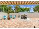 Charming backyard patio with a striped awning, outdoor seating, a fire pit, and lush landscaping for relaxing at 5726 20Th N Ave, St Petersburg, FL 33710