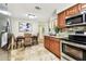Open kitchen and dining area with stainless appliances, granite countertops, and travertine flooring at 5726 20Th N Ave, St Petersburg, FL 33710