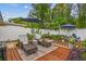 Landscaped backyard featuring lounge chairs, a dining set, manicured gardens, and a privacy fence at 5744 Thrush Dr, New Port Richey, FL 34652