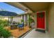Inviting front porch featuring a seating area and a vibrant red door adorned with a wreath at 5744 Thrush Dr, New Port Richey, FL 34652