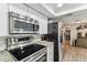 Modern kitchen features stainless steel appliances, white cabinets, and sleek granite countertops at 5744 Thrush Dr, New Port Richey, FL 34652