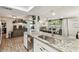 Open-concept kitchen and dining area featuring granite countertops, stainless sink, and bright lighting at 5744 Thrush Dr, New Port Richey, FL 34652