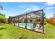 Backyard with screened in pool, lush green lawn and patio seating at 6289 107Th N Ave, Pinellas Park, FL 33782