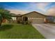 Exterior shot of a home featuring a well-kept lawn, large driveway, and attached two-car garage at 6289 107Th N Ave, Pinellas Park, FL 33782
