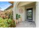 Inviting front porch with tile flooring, decorative plants, and an ornamental wall hanging at 6289 107Th N Ave, Pinellas Park, FL 33782