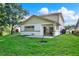 Landscaped backyard with grass, a small patio, and room for outdoor activities at 6439 Gentle Ben Cir, Wesley Chapel, FL 33544