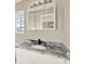 Bathroom with granite countertops, modern light fixture, and large mirror at 6439 Gentle Ben Cir, Wesley Chapel, FL 33544