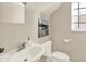 Half bathroom with white fixtures, artwork, and a small window at 6439 Gentle Ben Cir, Wesley Chapel, FL 33544