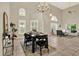 Inviting dining room with high ceilings, tiled floors, and a view of the living area creating an open and connected space at 6439 Gentle Ben Cir, Wesley Chapel, FL 33544