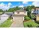 Charming two-story home with a well-manicured lawn and attached two-car garage on a beautiful sunny day at 6439 Gentle Ben Cir, Wesley Chapel, FL 33544