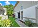 Home exterior with a view of the entryway, lush landscaping, and well-kept lawn in a peaceful setting at 6439 Gentle Ben Cir, Wesley Chapel, FL 33544