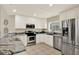 Modern kitchen with stainless steel appliances, sleek cabinets, and stone countertops at 6439 Gentle Ben Cir, Wesley Chapel, FL 33544