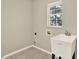 Laundry room with a utility sink and a window that provides natural light at 6439 Gentle Ben Cir, Wesley Chapel, FL 33544