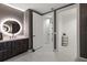 Stylish bathroom featuring a round, lighted mirror, dark cabinets, a white counter and tile flooring at 777 3Rd N Ave # 1304, St Petersburg, FL 33701