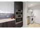 Stylish kitchen with stainless steel ovens and adjacent laundry area with stacked washer and dryer at 777 3Rd N Ave # 1304, St Petersburg, FL 33701
