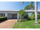 Charming home exterior with a well-maintained lawn, mature trees, and an attached garage for convenient parking at 8451 Candlewood Rd # 8451, Seminole, FL 33777