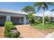 Inviting home exterior showcasing a well-manicured lawn, mature trees, and a convenient attached garage at 8451 Candlewood Rd # 8451, Seminole, FL 33777