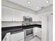 Bright kitchen featuring white cabinetry, stainless steel appliances, and black countertops at 8451 Candlewood Rd # 8451, Seminole, FL 33777