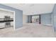 Open-concept living room with a view into the kitchen, featuring stainless steel appliances and ample counter space at 8451 Candlewood Rd # 8451, Seminole, FL 33777