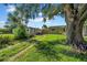Spacious backyard with a grassy lawn, mature trees, a fence, and two buildings at 8537 93Rd Ave, Seminole, FL 33777