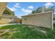 A view of the grassy backyard featuring siding, a small concrete patio, and a wooden fence at 8537 93Rd Ave, Seminole, FL 33777