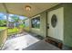View of the covered front porch with concrete flooring, and a welcome mat near the white front door at 8537 93Rd Ave, Seminole, FL 33777