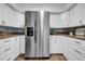 Bright kitchen with white cabinetry, stainless steel refrigerator and granite countertops at 8537 93Rd Ave, Seminole, FL 33777