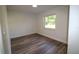Cozy bedroom with wood-look flooring and a bright window providing ample light at 8807 Mary Ivy Dr, Plant City, FL 33567