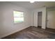 Bedroom with wood-look flooring, closet, and bright window offering a nature view at 8807 Mary Ivy Dr, Plant City, FL 33567