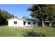 Charming single-story home featuring a metal roof, white brick facade, and a neatly manicured front lawn at 8807 Mary Ivy Dr, Plant City, FL 33567