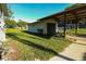 Detached garage and carport on a spacious lawn with green grass and a clear blue sky at 8807 Mary Ivy Dr, Plant City, FL 33567