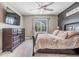 A spacious bedroom featuring light wood floors, a sleek TV, and ample natural light at 9028 Forge Breeze Loop, Wesley Chapel, FL 33545