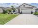Charming single-Gathering home featuring a well-manicured lawn, decorative plants, and a two-car garage in a sunny neighborhood at 9028 Forge Breeze Loop, Wesley Chapel, FL 33545