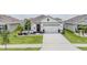 Charming single-Gathering home featuring a well-manicured lawn, decorative plants, and a two-car garage in a sunny neighborhood at 9028 Forge Breeze Loop, Wesley Chapel, FL 33545
