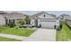Charming single-Gathering home featuring a well-manicured lawn, decorative plants, and a two-car garage in a sunny neighborhood at 9028 Forge Breeze Loop, Wesley Chapel, FL 33545