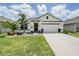 Charming single-story home featuring a two-car garage, manicured lawn, and decorative landscaping at 9028 Forge Breeze Loop, Wesley Chapel, FL 33545